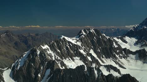 Montañas-Rocosas-Cubiertas-De-Nieve-En-El-Parque-Nacional-De-Aoraki-Mountain-Cook,-Alpes-Del-Sur,-Nueva-Zelanda-Desde-Un-Vuelo-Panorámico-En-Avión-Con-El-Lago-Glaciar-Pukaki-En-El-Fondo