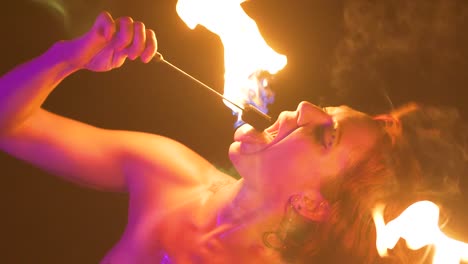 Slow-motion-beautiful-female-fire-eater-extinguishes-the-flame-in-her-mouth