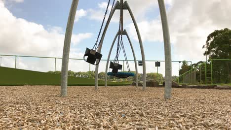 Empty-park-swings-move-to-and-fro-during-the-day-at-the-kids-playground