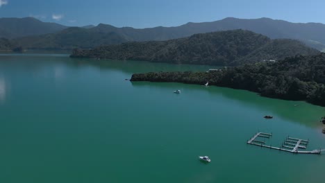 SLOWMO---Aerial-shot-of-sail-boats-and-jetty-in-Kenepuru-Sound,-Marlborough-Sounds,-South-Island,-New-Zealand