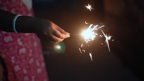 Unrecognizable-girl-holding-fire-cracker-at-night,-close-up-shot,-slow-motion