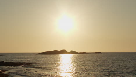 Kurzer-Ausschnitt-Eines-Sonnenuntergangs-Am-Meer-Mit-Einer-Kleinen-Insel-Im-Vordergrund
