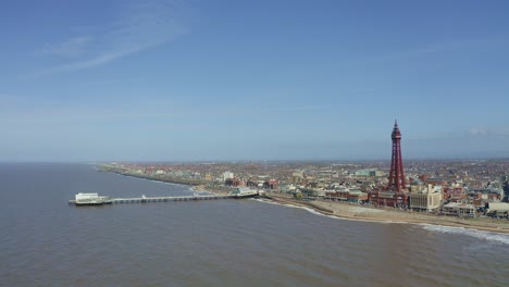Stunning-aerial-view,-footage-of-Blackpool-Tower-from-the-sea-of-the-award-winning-Blackpool-beach,-A-very-popular-seaside-tourist-location-in-England-,-United-Kingdom,-UK