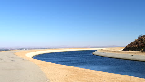 Schiebeaufnahme-Des-Kalifornischen-Aquädukts-Voller-Blauer-Wasserversorgung-Auf-Dem-Weg-Nach-Los-Angeles-Während-Einer-Dürre