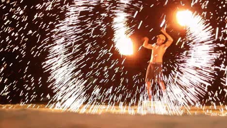 A-thai-man-spins-the-burning-steel-wool-into-milions-of-tiny-little-sparks-giving-a-remarkable-show-to-tourists-who-visit-Samet-Island,-Thailand