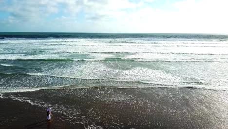 Amantes-Bailando-En-La-Playa,-Bethells-Beach-En-Nueva-Zelanda