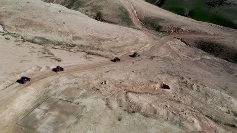 Fly-over-ATV-driving-in-the-desert,-drone-shot