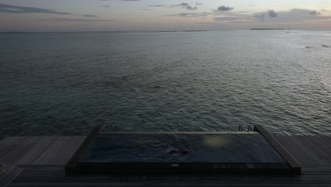 Woman-swims-in-an-infinity-pool-at-twilight