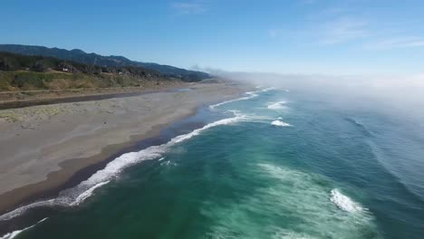 AERIAL:-Drone-shot-descending-towards-the-Oregon-coastline-as-the-waves-roll-in