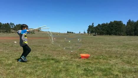 Child-Boy-making-giant-soap-bubbles-outdoors