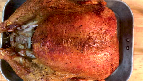 Large-delicious-looking-roast-turkey-sitting-in-a-pan-on-a-cutting-block