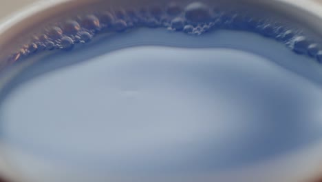 Water-droplets-falling-into-blue-coloured-water
