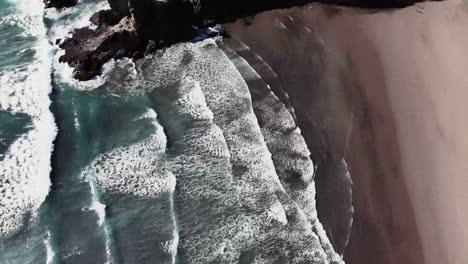 Bird-eye-view-flying-a-drone-over-the-surf-at-Piha-Beach-in-New-Zealand
