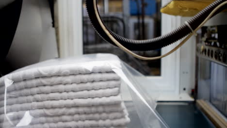 Weiße-Handtücher-Bewegen-Sich-Auf-Einem-Industrieband-Und-Sind-In-Transparenter-Schutzfolie-Verpackt