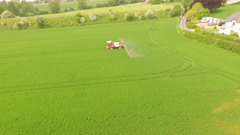 long-side-view-of-crop-spraying-by-tractor-in-field