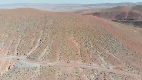 Aerial-View-of-a-dirt-road-near-a-popular-giant-cactus-canyon-near-San-Pedro-de-Atacama-in-the-Atacama-Desert,-northern-Chile,-South-America