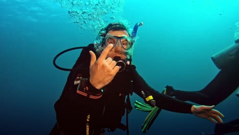 Diver-reaching-out-his-hand-to-take-over-camera