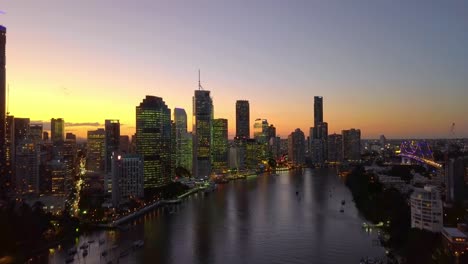 Fast-moving-aerial-view-of-a-city-riverside-at-sunset