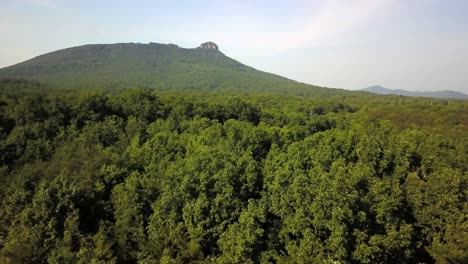 Aerial-shot-of-Pilot-Mountain-standing-in-the-distance