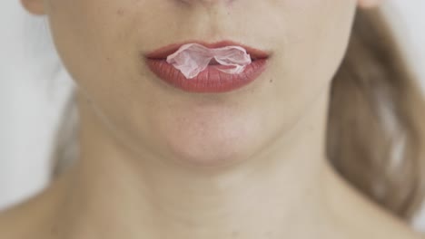 close-up-of-blonde-caucasian-young-girl-with-red-lips-chewing-gum-and-blowing-bubbles-,-hipster-pop-footage,b-roll-two