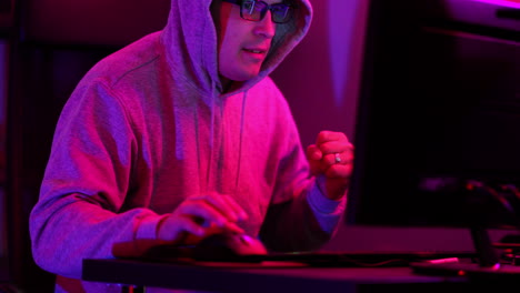 Hacker-with-a-hooded-sweathshirt-and-glasses-successfuly-hacks-a-computer-and-quickly-runs-off