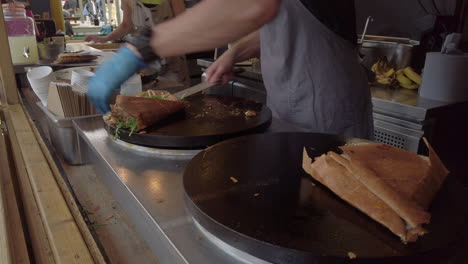 Savoury-crepes-being-cooked-on-an-open-air-hotplate-at-a-market-stall-in-York,-UK