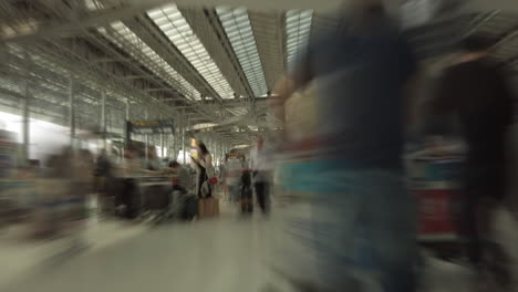 time-lapse-dolly-shot-with-abstract-motion-blur-of-a-cart-ride-through-the-busy-passenger-crowds-of-Suvarnabhumi-International-Airport's-Departure-Hall