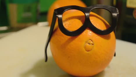 tracking-shot-of-the-orange-with-glasses,-smart-looking-orange-for-diet-plan