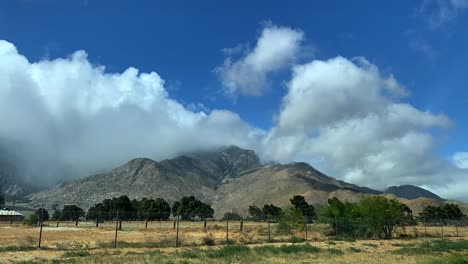 Lapso-De-Tiempo-De-4k-Del-Paisaje-Montañoso-Rural-Con-Nubes-Que-Soplan-Girando-Alrededor-De-La-Montaña-A-Través-De-Cielos-Azules
