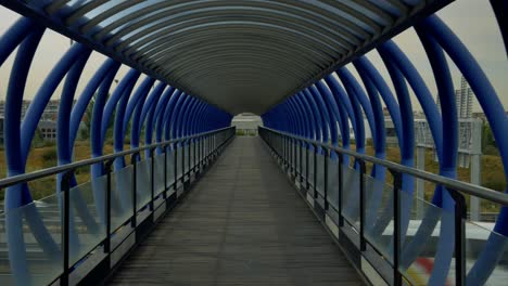 Überqueren-Einer-Brücke-Aus-Blauen-Metallrohren-über-Die-Autobahn-Zu-Fuß