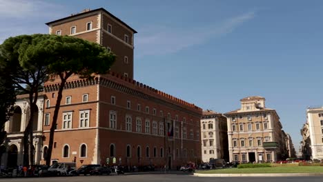 Toma-Panorámica-Que-Captura-El-Tráfico-Y-Los-Edificios-De-Piazza-Venezia,-Roma