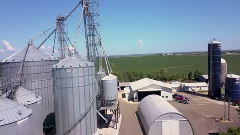 Low-flight-over-corn-field-to-reveal-grain-bins-on-farm