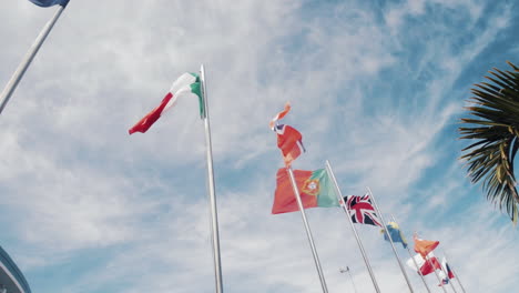 Banderas-Europeas-Y-Mundiales-Ondeando-En-Altos-Postes-De-Bandera