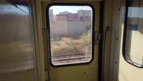 Blick-Auf-Gebäude-Aus-Dem-Fenster-Eines-Zuges,-Der-In-Der-Nähe-Von-Rabat-In-Marokko-Fährt