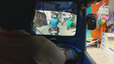 Toma-Pov-Desde-El-Interior-De-Un-Auto-Rickshaw-En-Medio-De-Una-Calle-Angosta-Llena-De-Gente-En-Yakarta