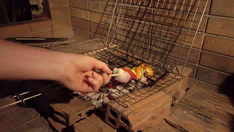 Handheld-Shot-of-Man-Removing-Vegetable-Kebabs-from-Charcoal-BBQ-Grill-at-Night