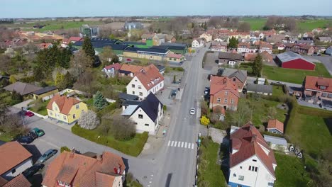 Aerial-Shot-of-a-Small-Town-Called-Löderup-In-South-Sweden-Skåne-With-a-White-Car-Driving