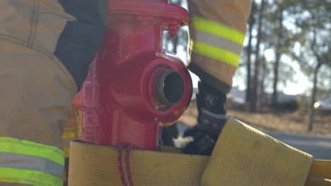 Firefighter-works-on-preparing-a-fire-hydrant-to-hook-up-a-fire-host-to-it-for-firefighting