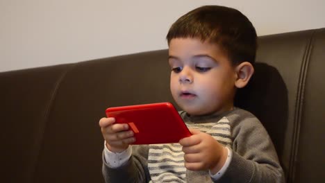 Süßer-Zweijähriger-Junge,-Der-Spiele-Auf-Dem-Smartphone-Spielt