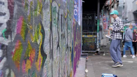 Young-Graffiti-Artist-Painting-With-Red-Spray-Paint-in-hoiser-lane,-melbourne-July,-2019
graffiti-on-wall,-street-spray-artwork-in-Hosier-Lane-Melbourne-CBD