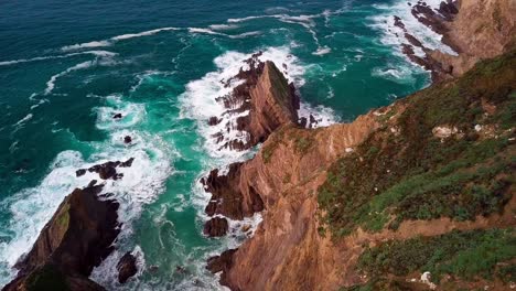 Flying-Down-Huge-Rock-Cliff-with-Breaking-Ocean-Waves-in-Big-Sur,-Cali