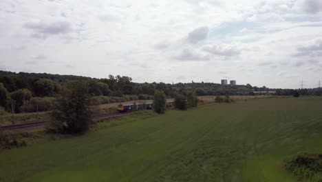 Rising-Pedestal-Shot-of-Northern-Train-Passing-By-the-Rural-Outskirts-of-Leeds