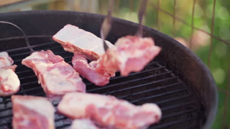 Slow-Motion-of-Tongs-Laying-Meat-on-Smokey-BBQ-Grill