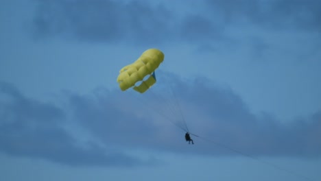 Ein-Paar-Beim-Parasailing,-Hängend-An-Einem-Gelben-Fallschirm-Auf-Einer-Tropischen-Insel