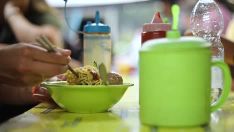 Shot-of-someone-eating-their-indonesian-food-and-playing-with-their-noodles