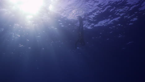 Underwater-shot-of-a-freediver-going-deep-down-in-mediterranean-sea