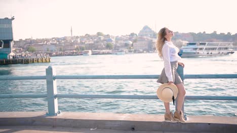 Beautiful-girl-stands-over-Galata-Bridge-and-enjoys-view-of-bosphorus-in-Istanbul,Turkey