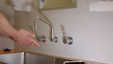Man-uses-Elbow-to-Turn-On-Tap-In-Hospital-and-Wash-Hands