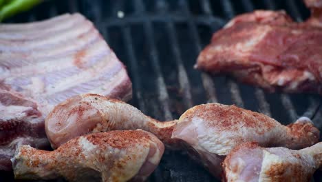 ribs-and-spice-rubbed-chicken-legs-on-outdoor-grill-closeup-showing-flames-and-smoke-with-copy-space
