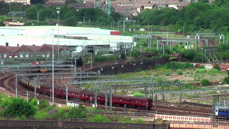 Static-Shot-of-the-Flying-Scotsman-60103-Steam-Train-Waiting-Outside-Leeds-Station-Amongst-Modern-Trains
